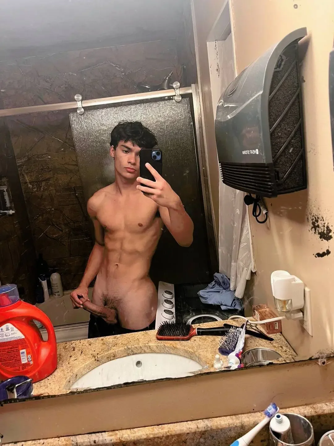 nipples, indoors, navel, standing, selfie, naked, nude, black hair, solo, male, penis, erection, male only, 1boy, balls, male focus, pubic hair, white male, testicles, bathroom, muscular, abs, trimmed, mirror, muscular male, short hair, masturbation, phone, holding, trimmed penis, looking at phone, male pubic hair