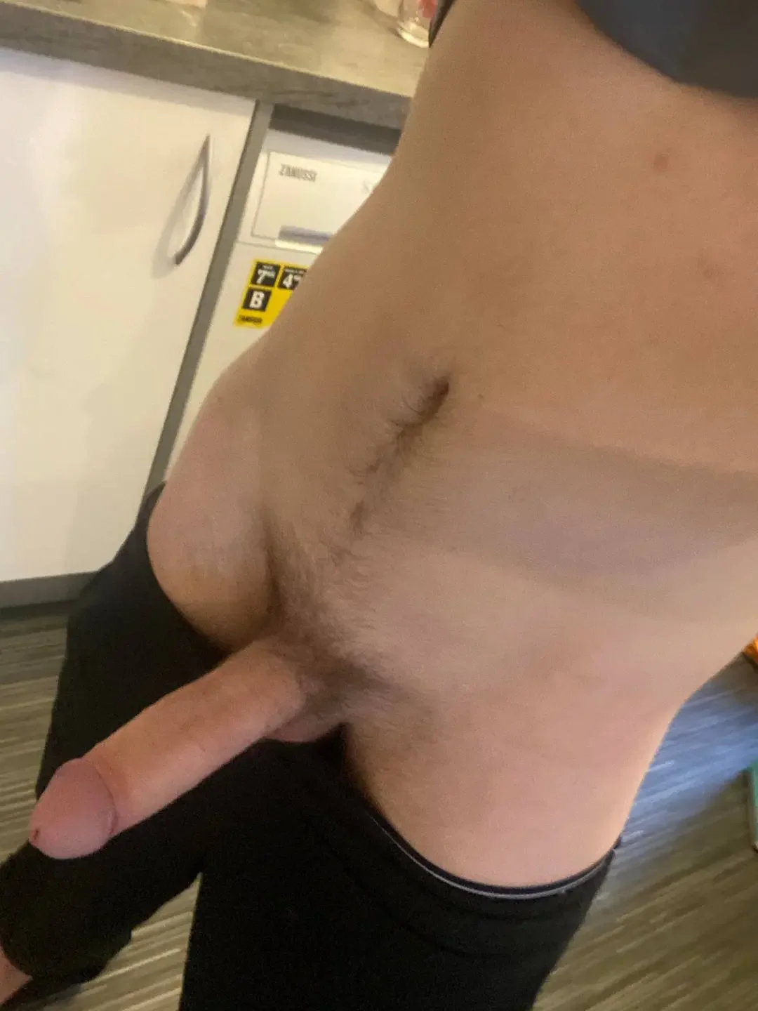 indoors, navel, standing, solo, stomach, partially dressed, male, penis, male only, erection, 1boy, balls, male focus, testicles, white male, trimmed, pants, trimmed penis, pants pull, black pants