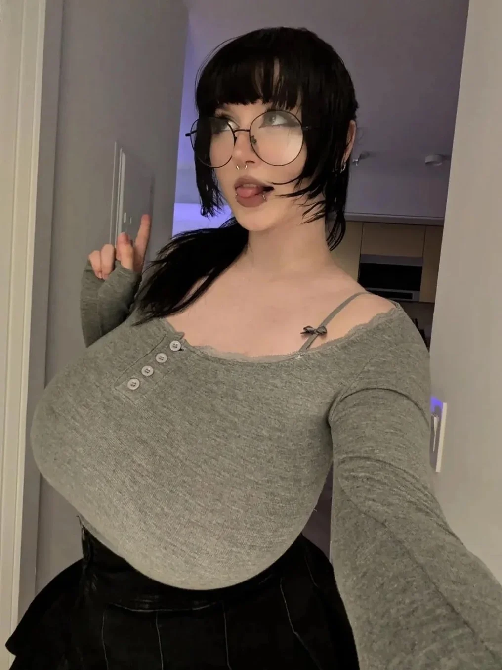 mylittlerobin, robin grey, greylittlerobin, 1girl, female only, breasts, long hair, front view, indoors, medium hair, makeup, standing, selfie, piercing, black hair, fringe, bangs, non-nude, nose piercing, tongue out, busty, glasses, earrings, septum piercing, ear piercing, huge breasts, tongue, long sleeves, lip piercing, skirt, looking aside, black skirt, twitter, grey shirt