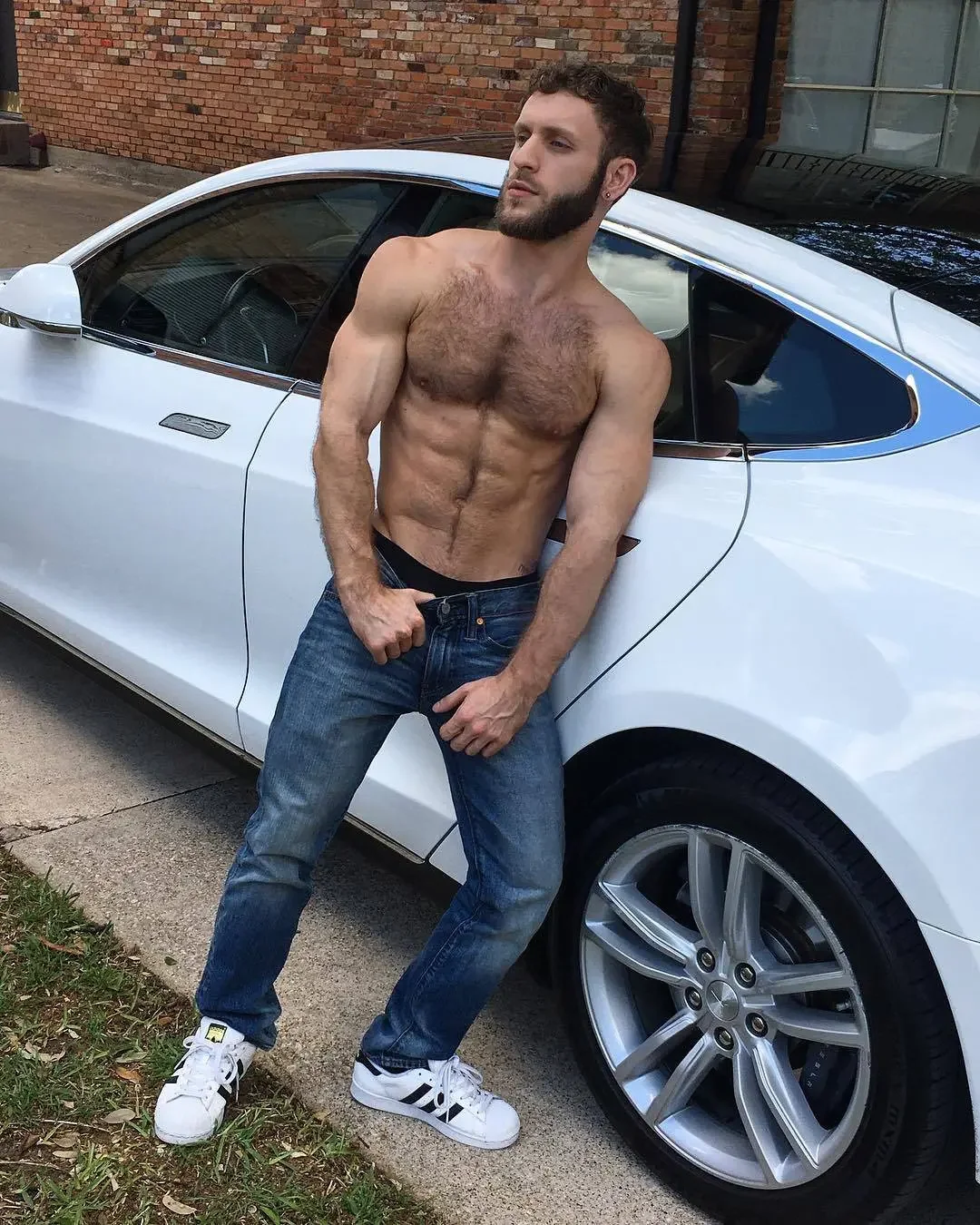 nipples, navel, standing, black hair, solo, partially dressed, dark hair, male, male only, 1boy, male focus, outdoors, topless, white male, muscular, abs, muscular male, short hair, pectorals, pants, full body, jeans, sneakers, topless male, shoes, chest hair, car, beard, facial hair, arm hair, denim, navel hair, motor vehicle