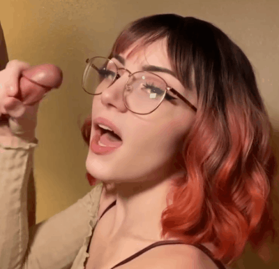 1girl, white female, light-skinned female, medium hair, brown hair, makeup, pale-skinned female, fringe, dyed hair, clothed, pale, penis, 1boy, red hair, tongue out, cum, multicolored hair, eyeliner, glasses, open mouth, gif, curly hair, cum on face, ejaculation, gradient hair, orange hair, facial, cum on hair, faceless male, handjob