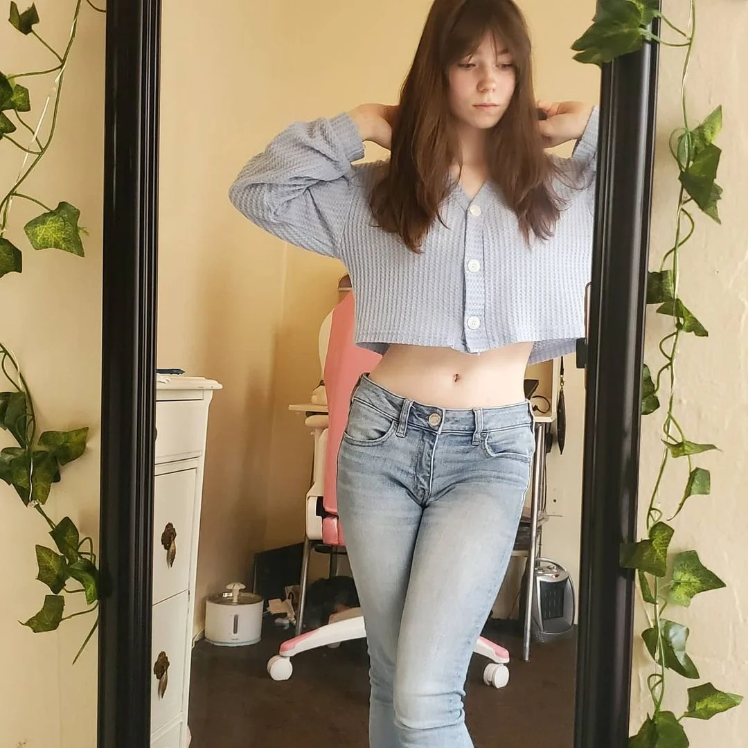 classic cassi, sassy cassi, sassycassi, 1girl, female only, white female, light-skinned female, long hair, front view, brown hair, navel, standing, stomach, fringe, bangs, non-nude, waist, slim body, teen, shirt, pants, jeans, looking down, hands up