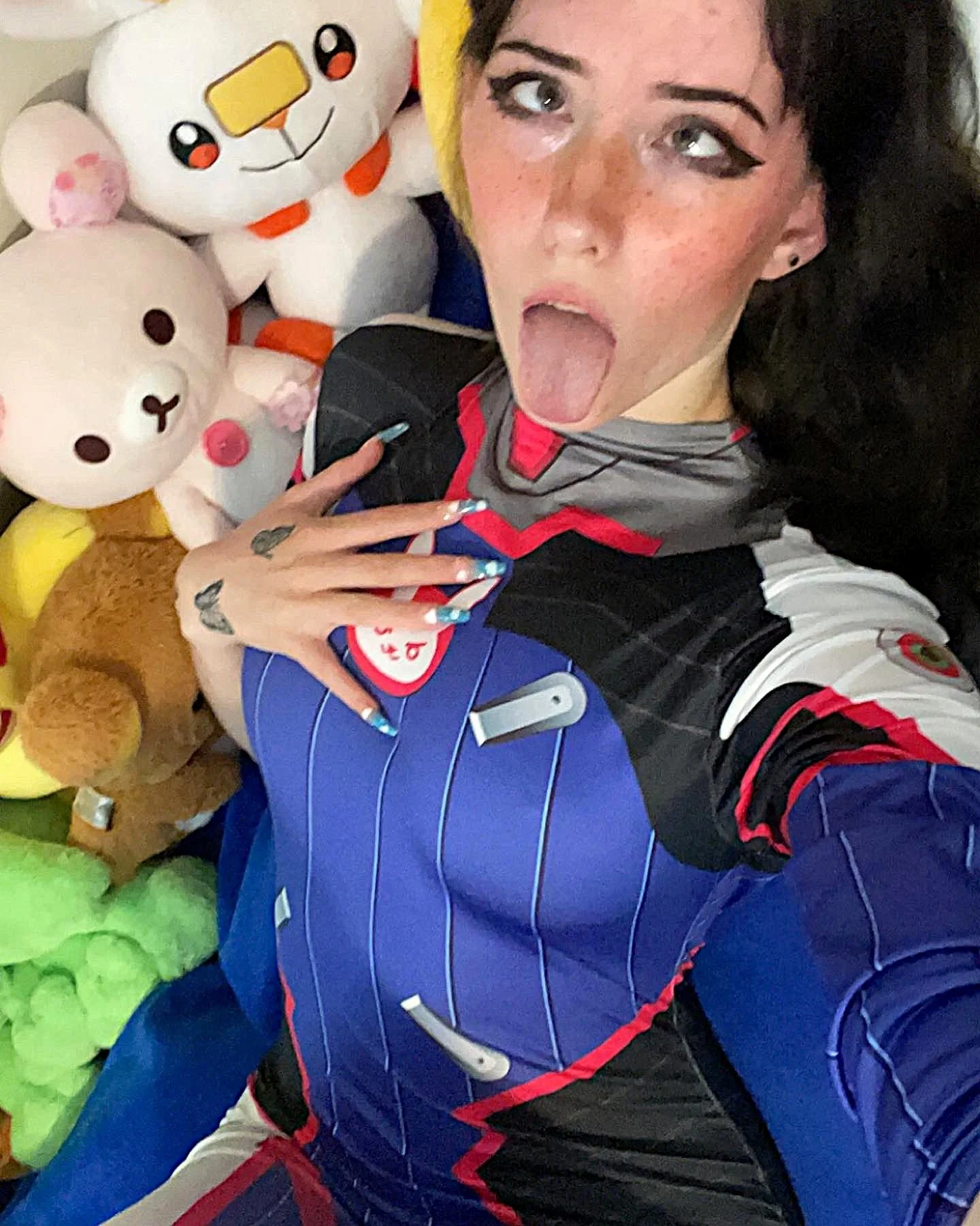 sakurasakelovey, 1girl, female only, white female, light-skinned female, long hair, front view, indoors, makeup, selfie, black hair, sitting, tattoos, non-nude, tongue out, freckles, cosplay, ahegao